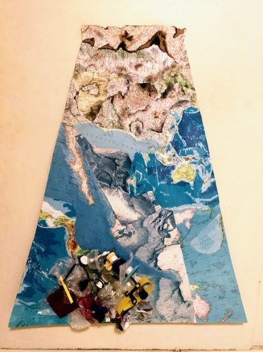 Cardboard skirt with maps of burning land and gyre of plastic in the ocean